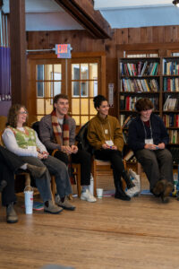 Campus Commons participants talk to each other in front of a bookcase.